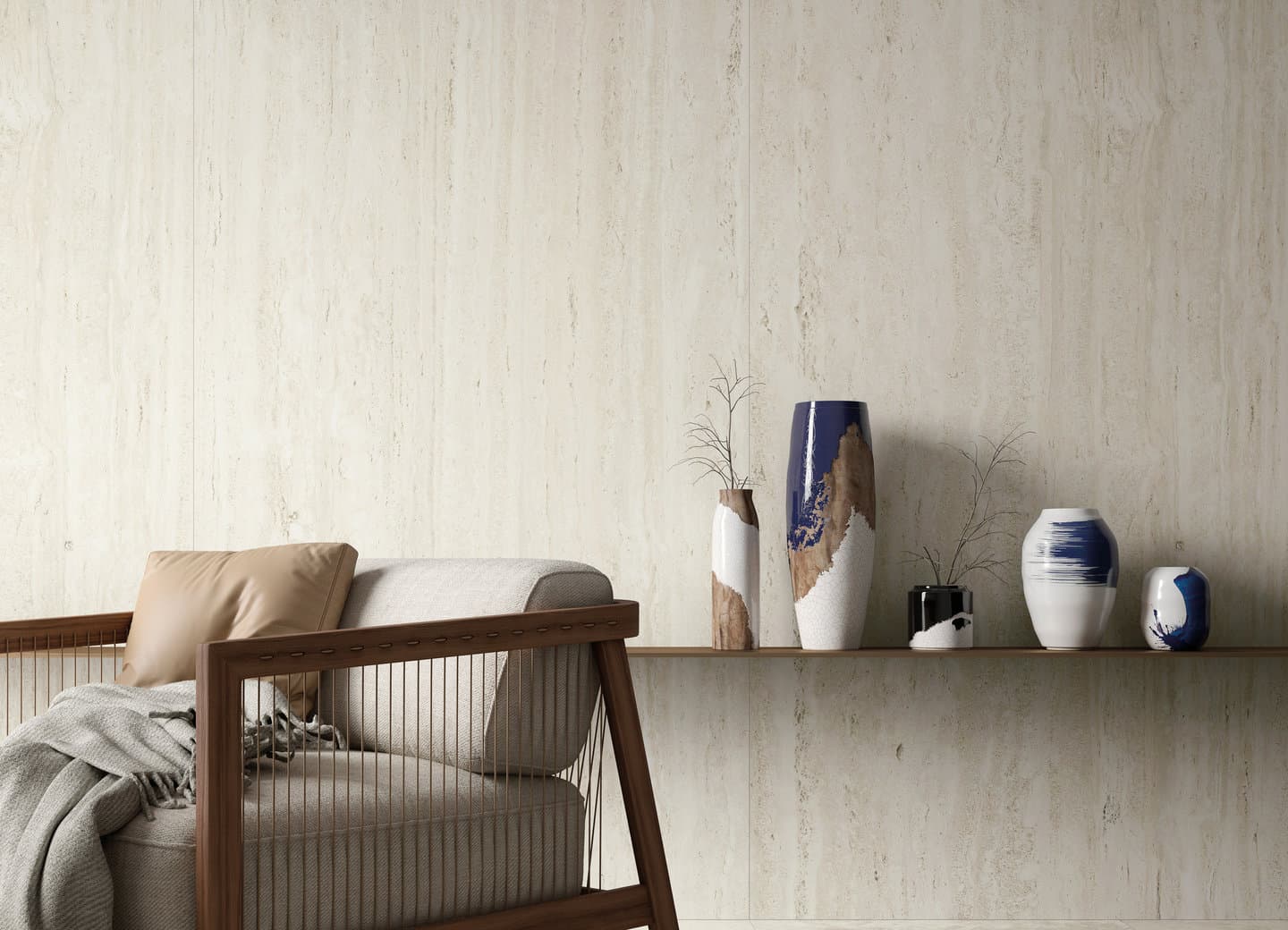 Cream travertine-look wall behind a woven lounge chair and blue-and-white ceramic vases