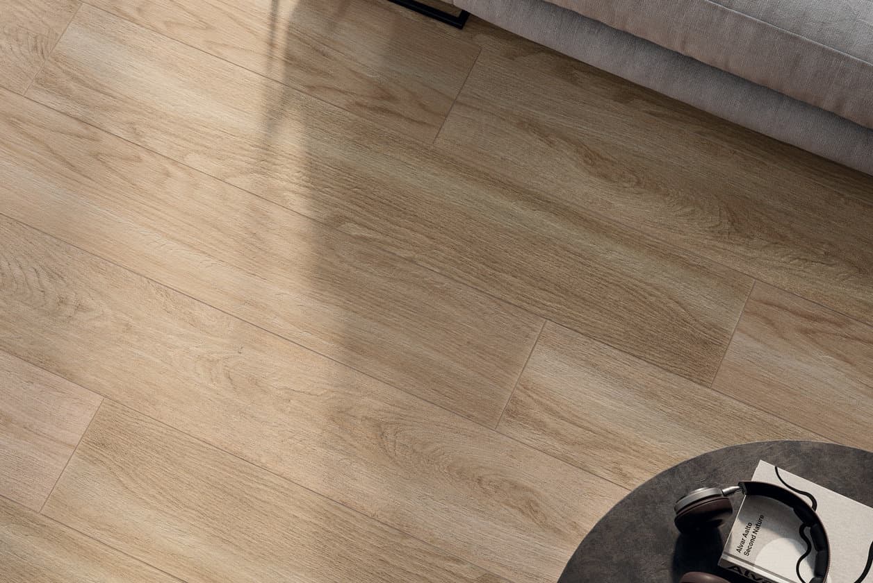 Warm wood plank floor with a dark rug, book and headphones