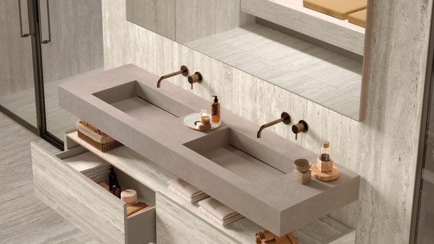 Travertine bathroom with a long stone double basin and bronze wall taps