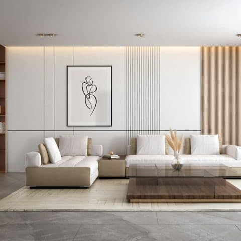 Low cream three-seater sofa with a taupe leather base, against a fluted plaster wall