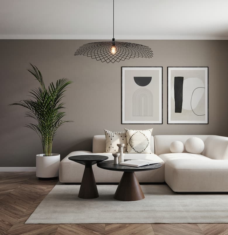 Cream sofa beneath a wire pendant with two black-and-white framed prints