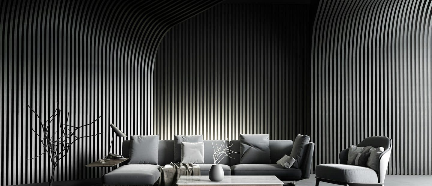 Dark showroom room with a curved slatted ceiling, a grey sofa and low armchairs